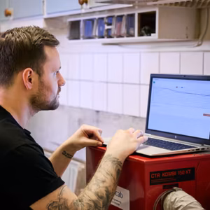 Ocab-personal kollar inomhusmiljö-statistik på en laptop i ett kök